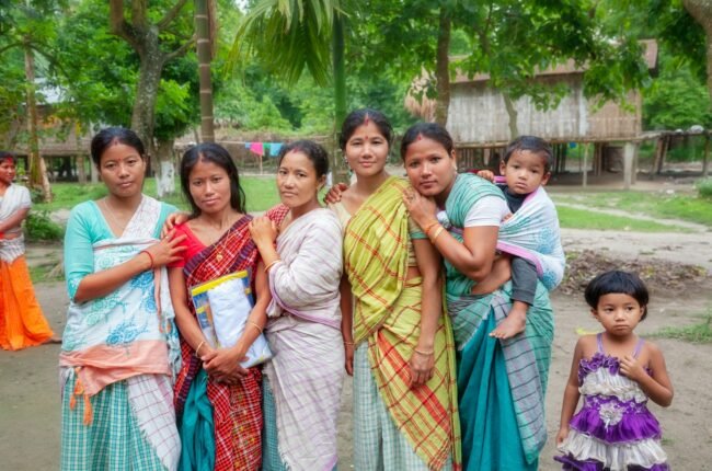 Group of women and children in a rural village setting