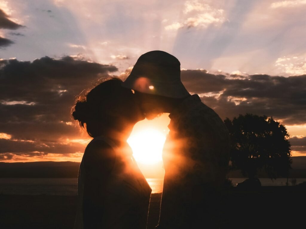 silhouette of man and woman kissing during sunset