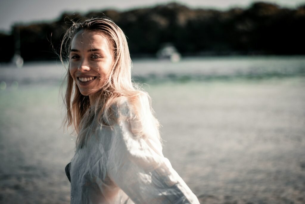 a person with long hair smiling